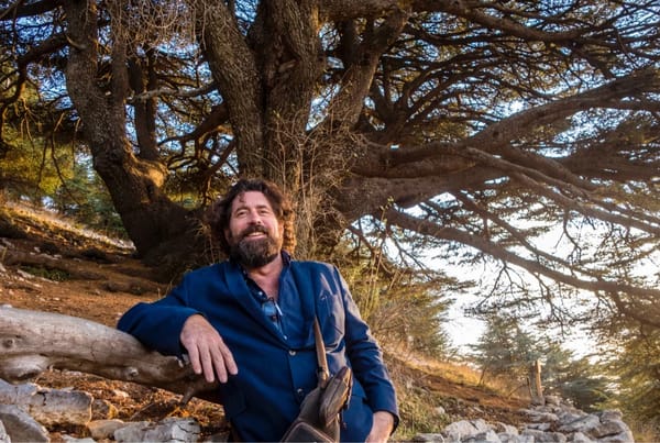 A man standing by a tree smiling 